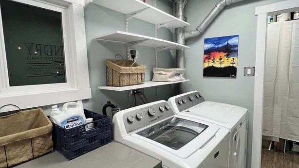 A laundry room with a washing machine, shelves, and a window with a view. - Fresh Walkable Fremont Home Near Ballard/Downtown (Seattle)