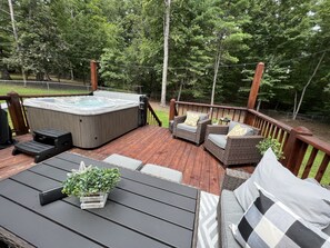 Terraza con hidromasaje, mobiliario de mimbre y una planta en maceta.