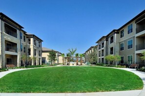 Stylish apartment complex with a central courtyard and well-maintained lawn.