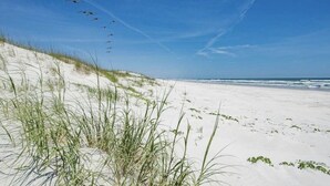 A beach with sand dunes and a clear sky.