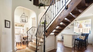 A staircase with a wooden finish and black balusters leading to an upper floor.