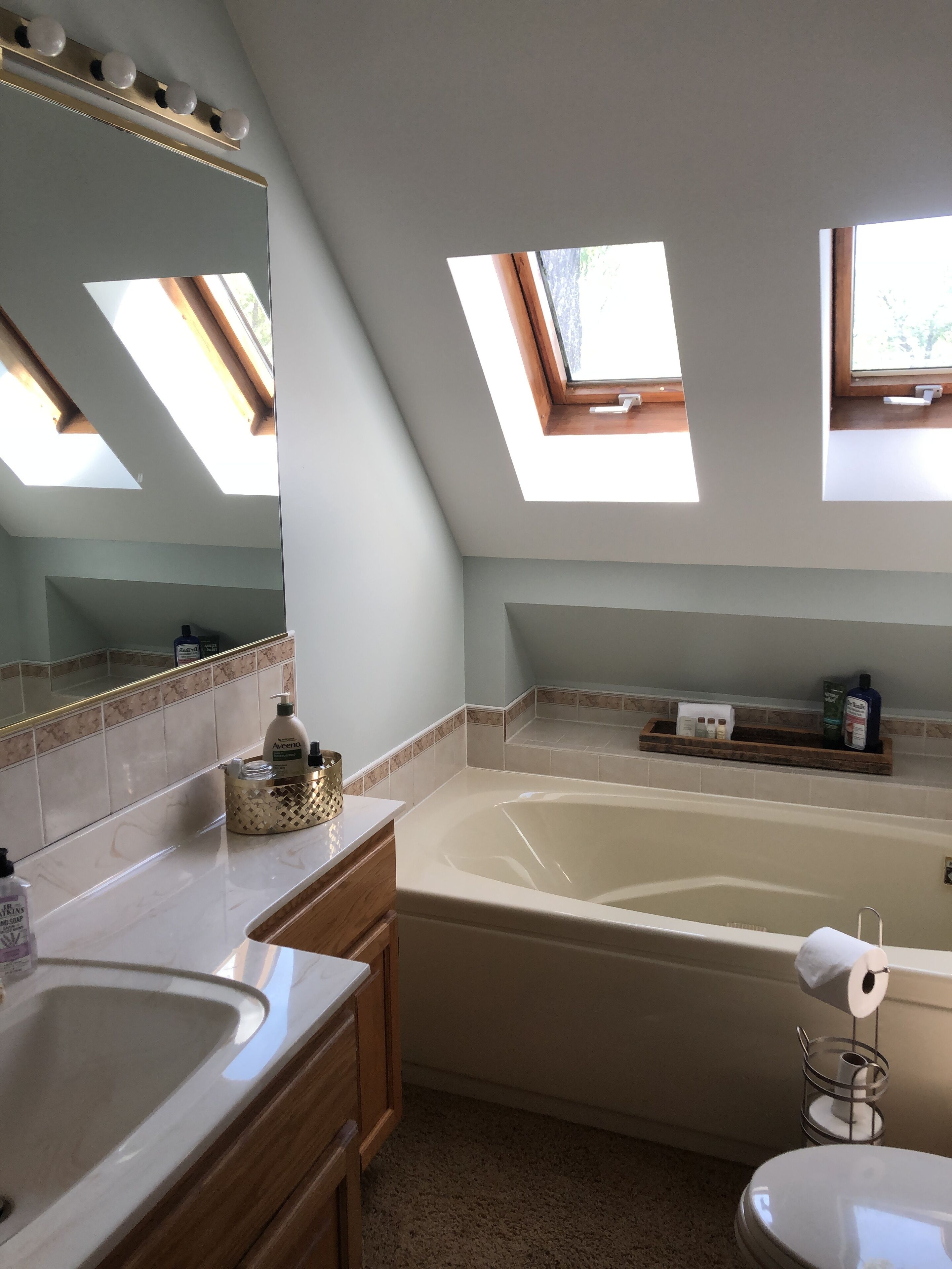 Ein modernes Badezimmer mit Oberlicht, Badewanne, Waschbecken und Toilette.