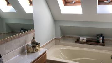 Ein modernes Badezimmer mit Oberlicht, Badewanne, Waschbecken und Toilette.