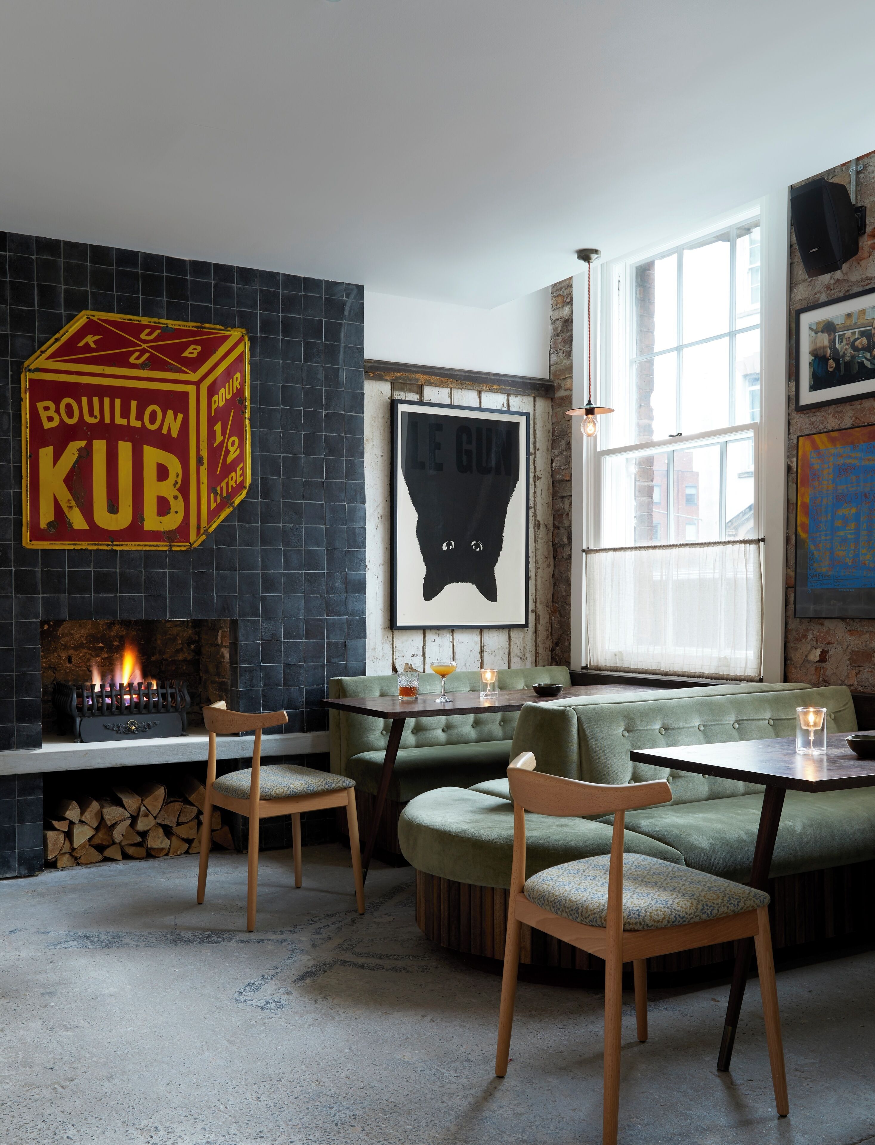 A cozy interior with a fireplace, seating area, and artwork.