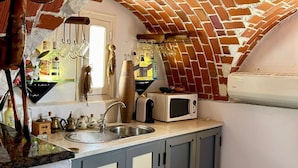 A kitchen with a brick ceiling, a sink, cabinets, and a microwave. - Dream room (Hergla)