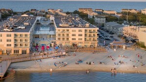 Ett hotell vid stranden med flera byggnader, en strandpromenad och en sandstrand.