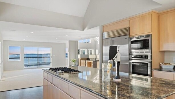 A modern kitchen with granite countertops, stainless steel appliances, and wooden cabinets. - Relaxing in an Entire 5,400sf Beach View Home With Indoor Heated Swimming Pool. (Federal Way)