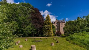 A castle with a well-maintained lawn and stone stumps. - Historic Fairytale Lickleyhead Castle (Insch)