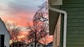 A hot tub with a view of houses and trees during sunset. - Cozy, 2-bedroom vacation home. 1 mile to DT: Hot Tub, 86" TV, Golf & Fenced Yard (Sioux Falls)