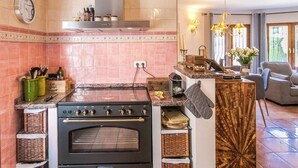 Une cuisine équipée d’une cuisinière, d’un four et d’un coin repas avec un canapé.