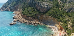 Cala Llibeig, a coastal property with rocky cliffs and clear turquoise waters.