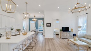 A modern kitchen with white cabinets, a central island with bar stools, and pendant lighting. - Luxury 5BR Home, Walk to French Quarter!! (New Orleans)