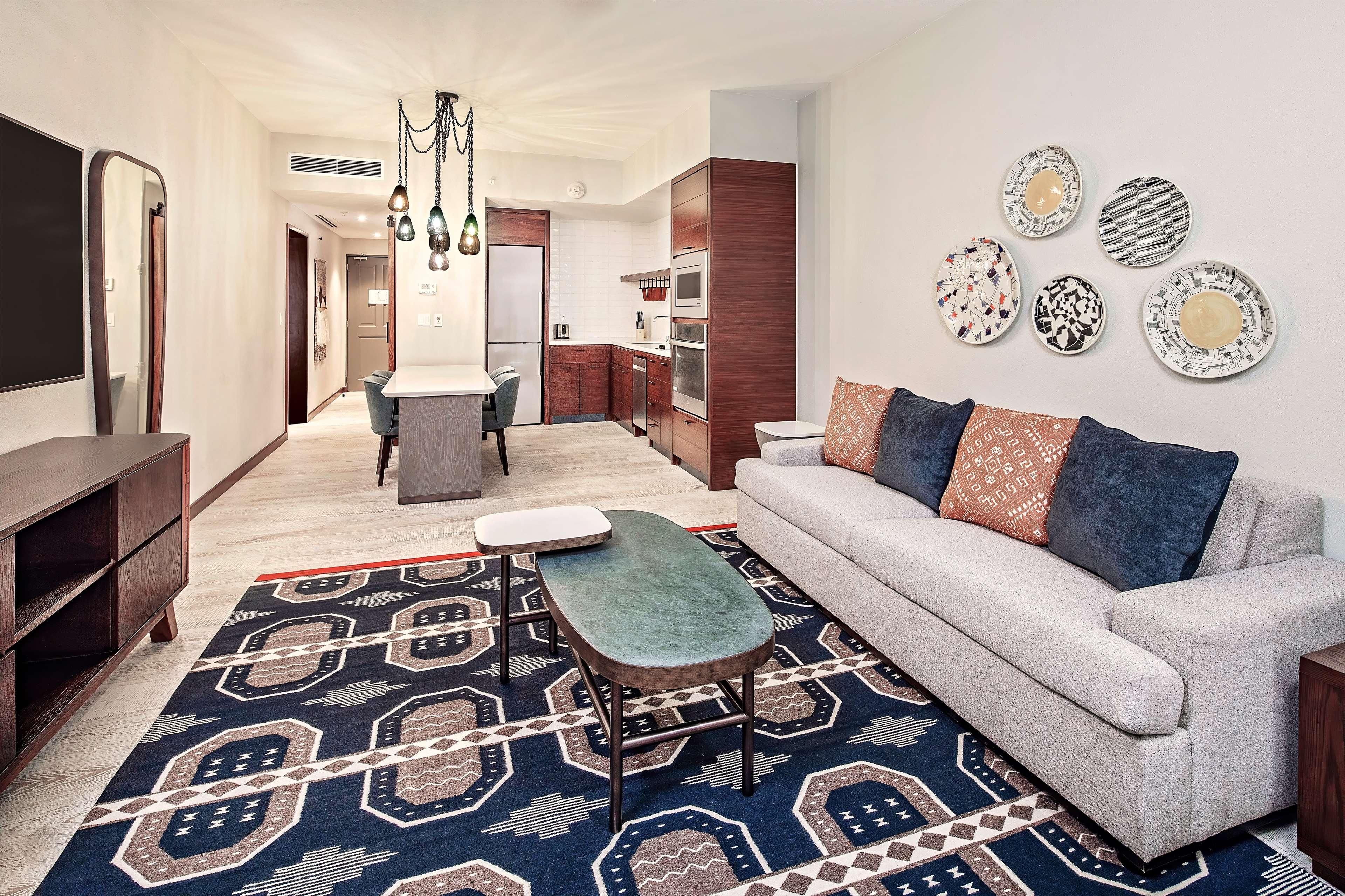 Una sala moderna con sofá, mesa de centro y alfombra estampada.