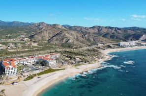 A coastal resort with multiple buildings, a beach, and mountainous terrain in the background. - Hilton Grand Vacations Club La Pacifica Los Cabos (San José del Cabo)