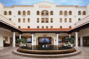 A Hilton hotel with a courtyard, a fountain, and potted plants. - Hilton Grand Vacations Club La Pacifica Los Cabos (San José del Cabo)