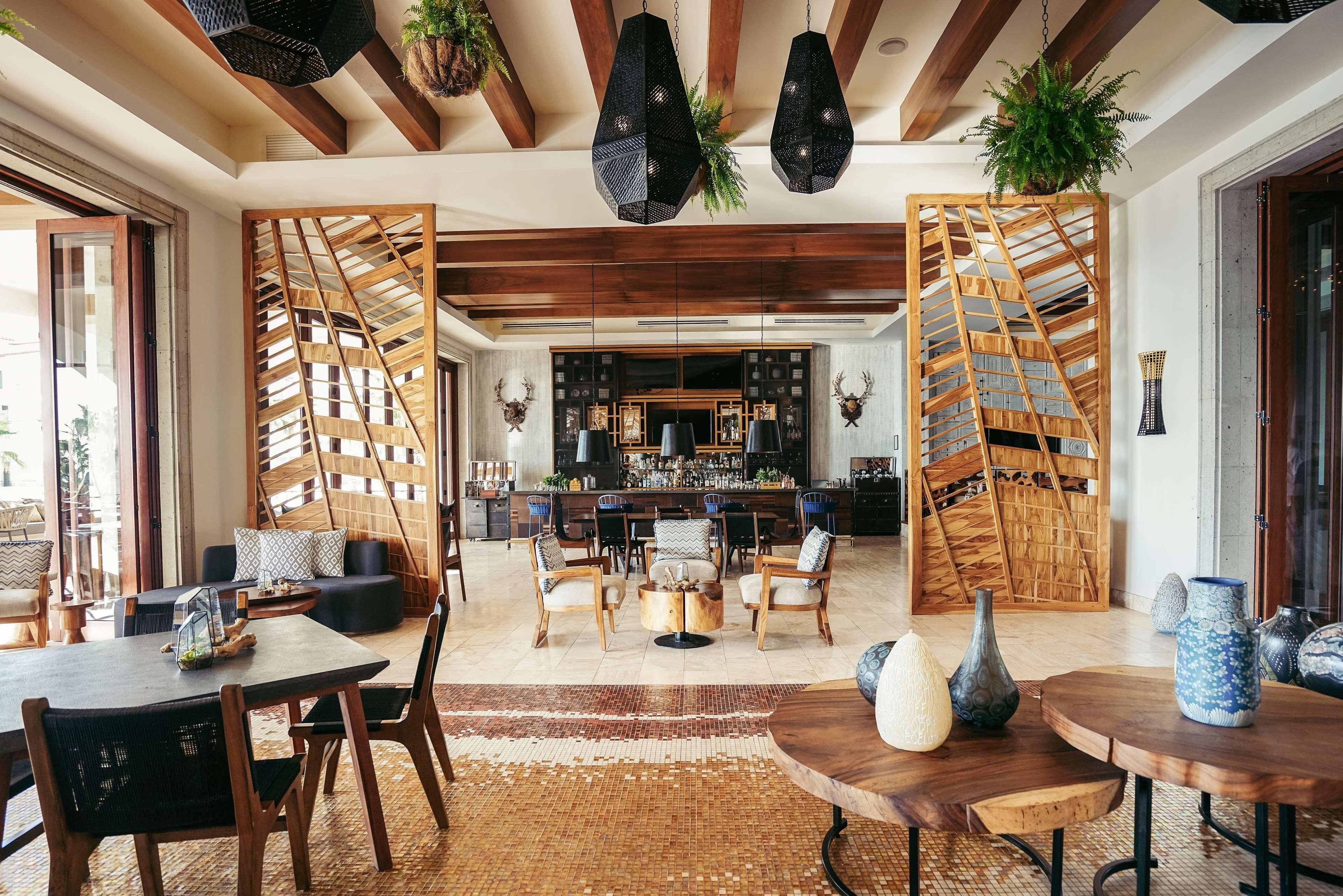 A spacious living area with a wooden ceiling, a bar area, and a seating arrangement.