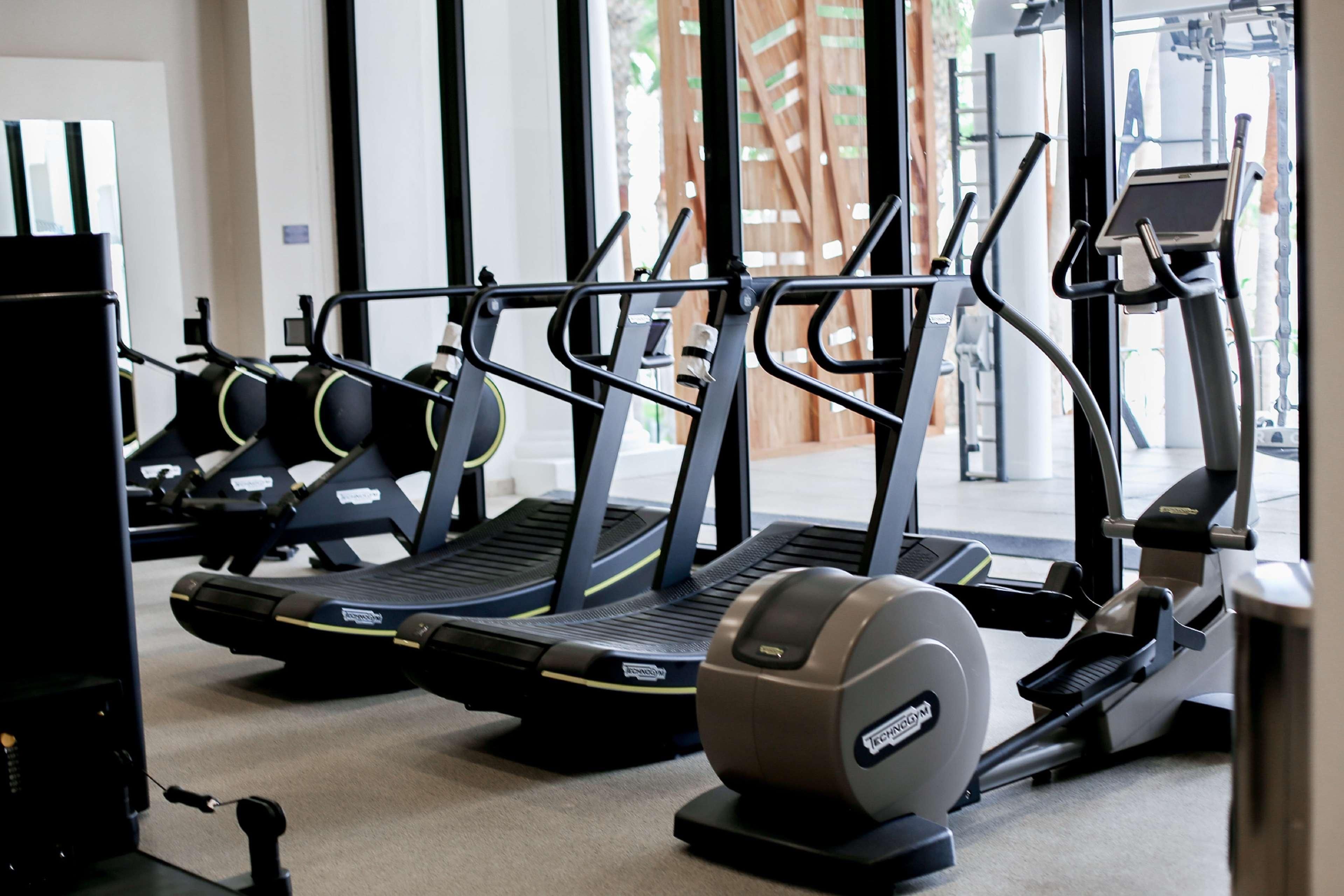 A gym with treadmills, stationary bikes, and a rowing machine.