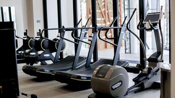 A gym with treadmills, stationary bikes, and a rowing machine.