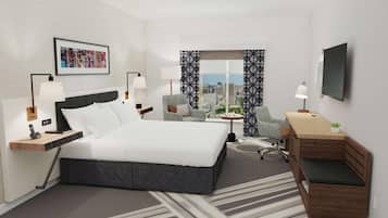 A hotel room with a bed, two chairs, a desk, a TV, and a city view.