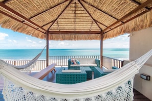 A hammock and seating area with a view of the ocean.
