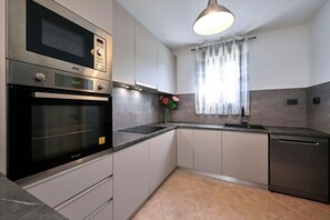 Kitchen features a microwave, oven, sink, and dishwasher.