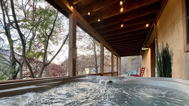 Un jacuzzi con terraza de madera y vistas a árboles.