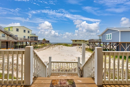 A beach view with wooden walkways leading to beach houses.