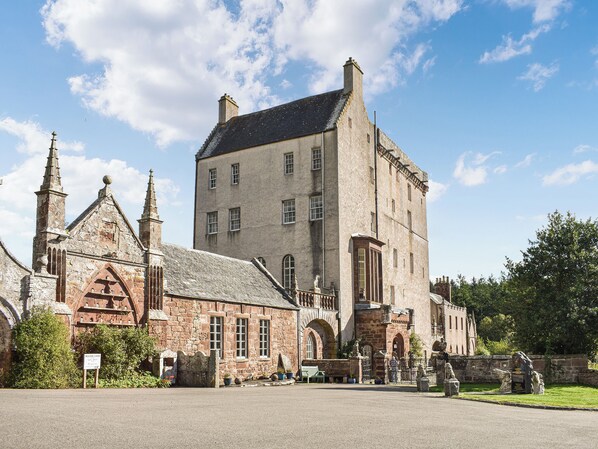 A historic building with a prominent tower, arched windows, and a stone facade.