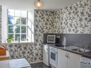A kitchen with a window, a microwave, an oven, and a sink. - A fantastic and truly unique holiday suite located within the main castle. (Delgaty, near Turriff)