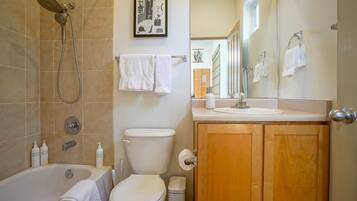 Een bad/douchecombinatie, een haardroger, handdoeken, zeep