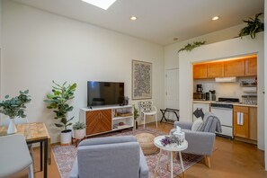 A compact living space with a sofa, TV, dining table, and kitchen area. - Downtown Modern Studio, centrally located (Albuquerque)