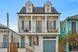 A two-story house with a balcony, a garage, and a wooden fence. - Beautiful Home in the Marigny Triangle, Walk to French Quarter!! (New Orleans)