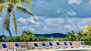 A pool area with lounge chairs and palm trees. - Caribbean Dream - located in the community of Coakley Bay! (Christiansted)