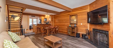 Un intérieur chaleureux en bois, avec un canapé, une table basse et un coin repas.