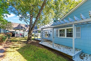 A blue house with a covered porch and a tree in the yard. - Picturesque Home in Downtown Auburn (Auburn)
