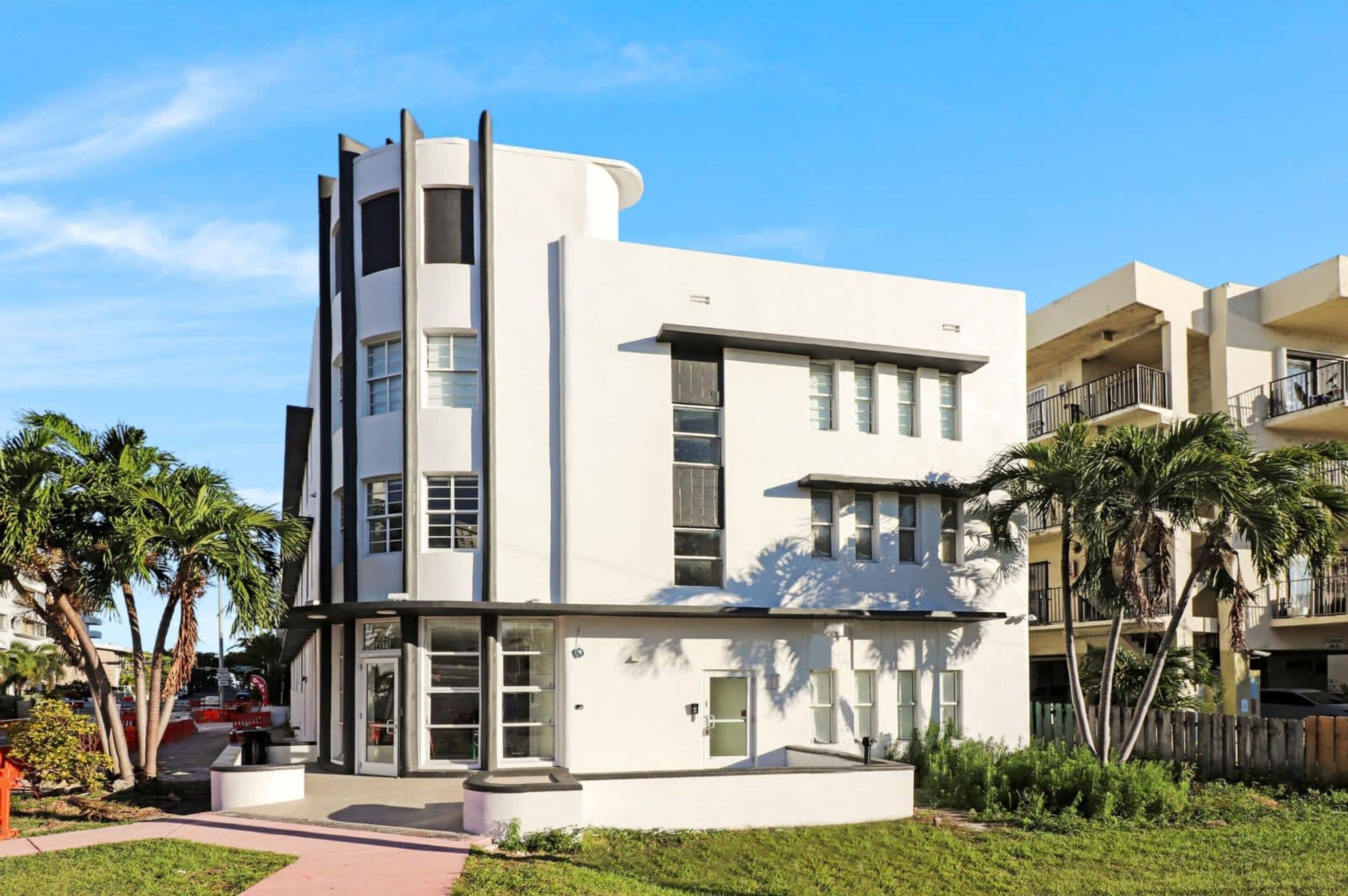 A modern multi-story building with a flat roof, large windows, and a flat facade.
