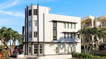 A modern multi-story building with a flat roof, large windows, and a flat facade.