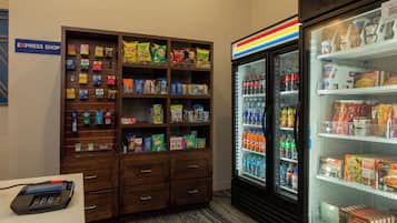 Un área de refrigerios y bebidas con una sección refrigerada y una exhibición de diferentes productos.