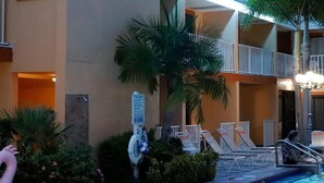 Un hotel con zona de piscina, incluyendo sillas de descanso y puesto de socorrista.