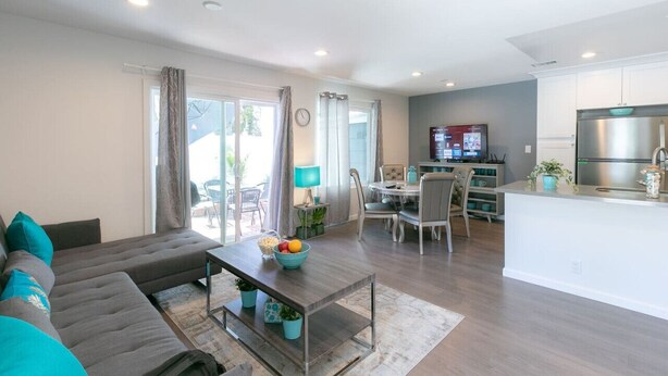 A modern living room with a sofa, coffee table, and dining area.