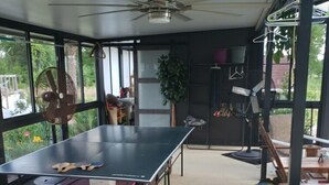 A spacious room with a ping pong table, a ceiling fan, and large windows offering a view of the outdoors. - RV Executive Home #4, Indoor - Inground Pool ..Jacuzzi heated by request (Cottondale)