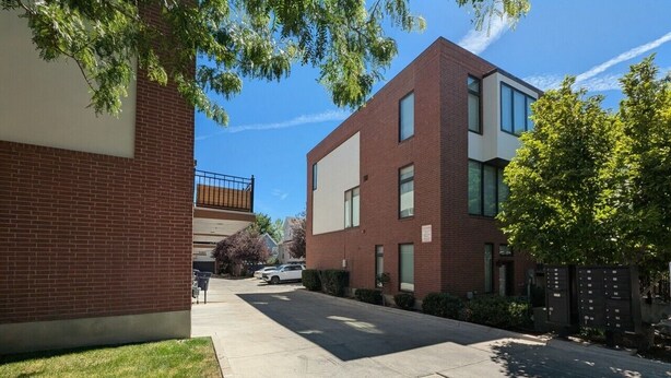 Un bâtiment moderne avec une façade en briques, un toit plat et une porte de garage visible.