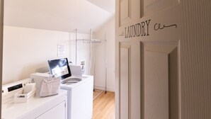 Une buanderie moderne équipée d’un lave-linge, d’un sèche-linge et d’un étendoir.