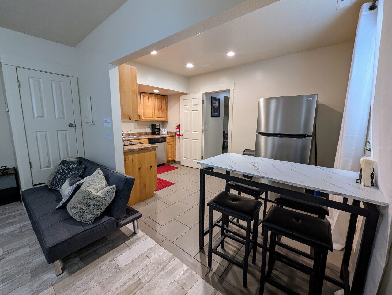 A compact living space with a kitchenette, a dining area, and a sofa.