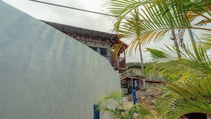 Un quartier résidentiel avec un grand mur gris, un balcon et quelques plantes.