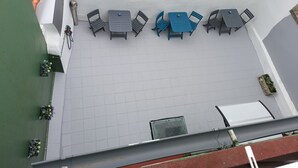 A rooftop terrace with a seating area, a small table, and potted plants. - Casa Douro (Santiago de Compostela)