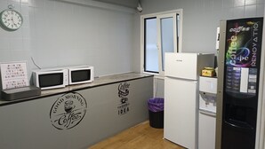 A compact kitchenette with a microwave, a small refrigerator, and a coffee machine. - Casa Douro (Santiago de Compostela)