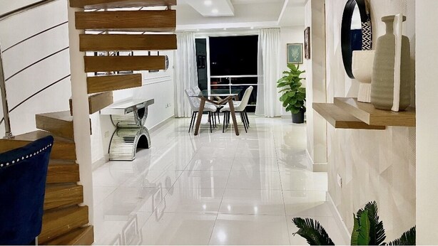 A modern interior with a staircase, dining area, and a view through a large window. - Penthouse Jacuzzi and Private Barbecue Exclusive (Santo Domingo)