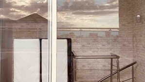 A room with a view of a cloudy sky and distant mountains through a glass window. - Penthouse Jacuzzi and Private Barbecue Exclusive (Santo Domingo)