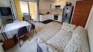A compact living space with a kitchenette, a dining area, and a sofa. - Waterfront T2 apartment (Les Trois-Îlets)